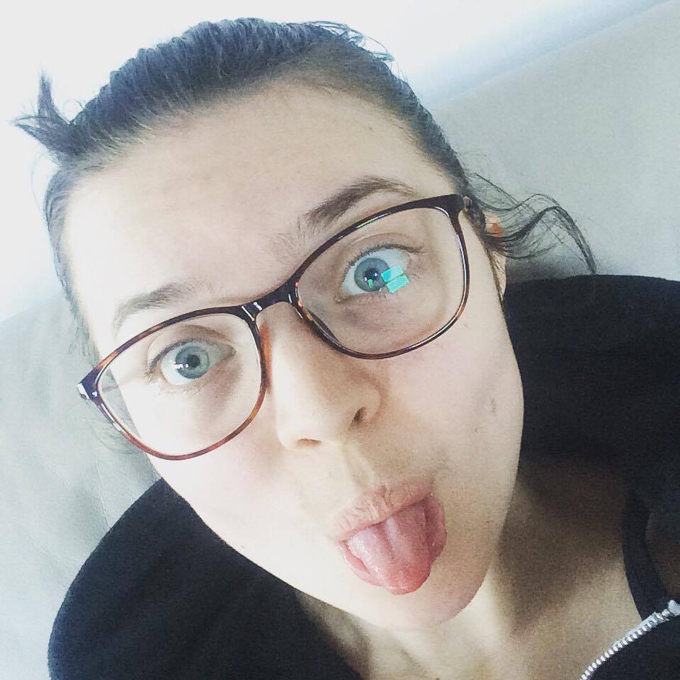 A selfie of Jenni, wearing glasses, sticking her tongue out.