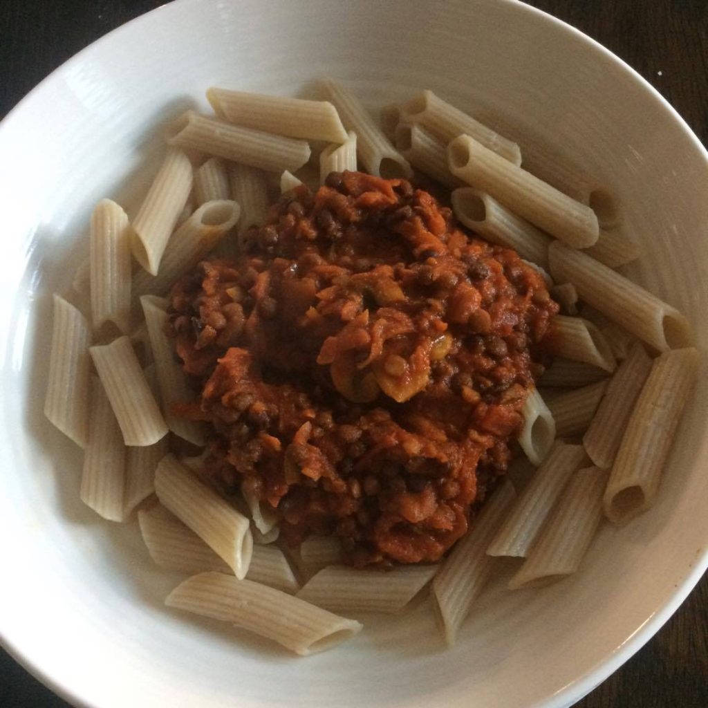 A bowl of pasta with sauce.