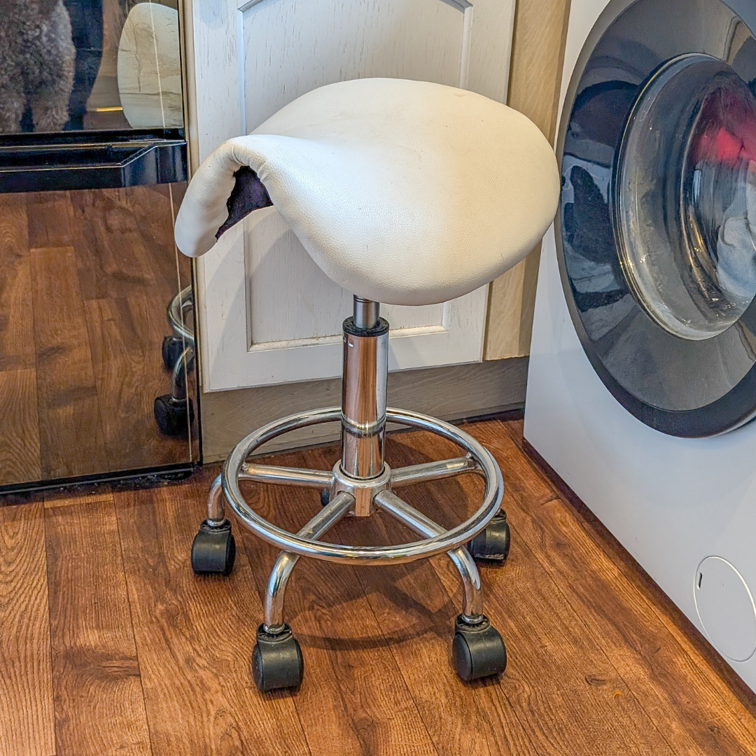 A white saddle stool sitting in a kitchen
