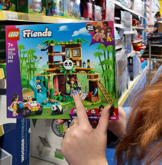 jenni holding a lego friends set pointing out autumn who has a limb difference to her arm