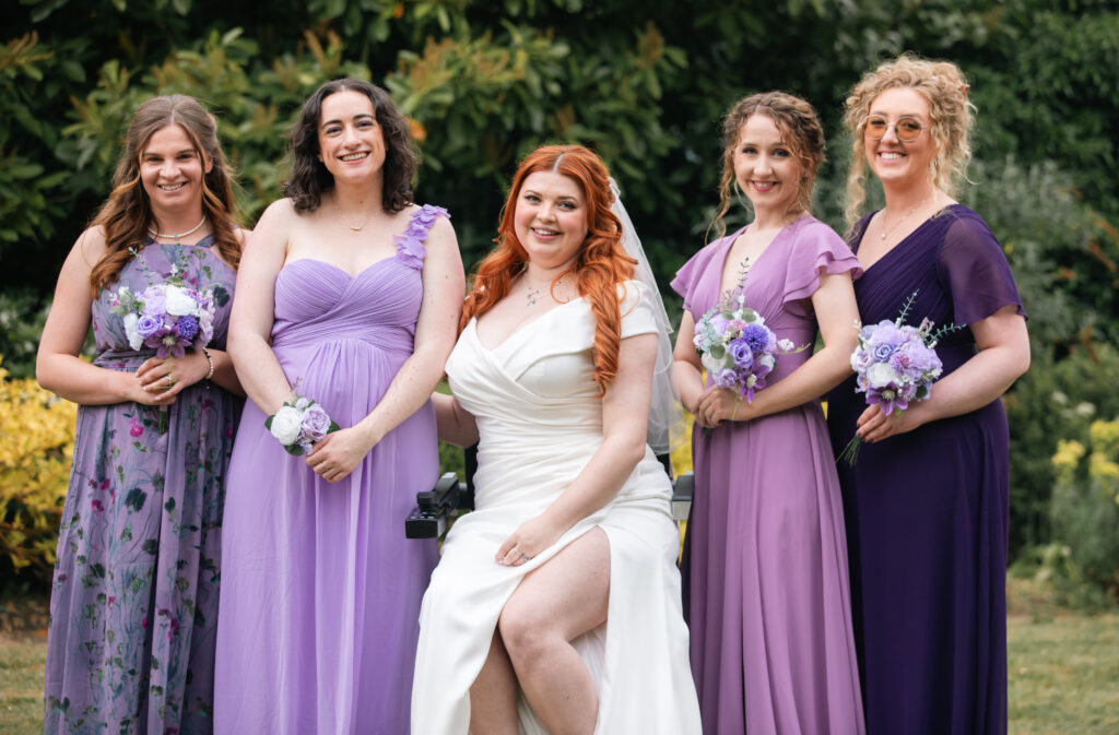 Jenni and her 4 bridesmaids Poppy, Sally, Beth and Hannah on her wedding day. all the bridesmaids wear purple