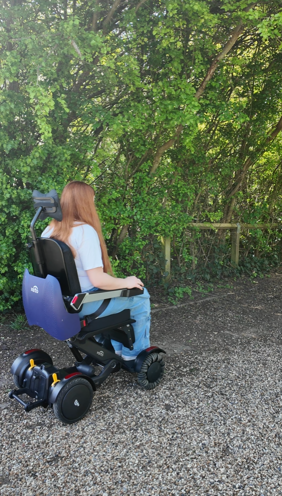 a photo from the back of the XSTO M4 powerchair as Jenni goes across a gravel path